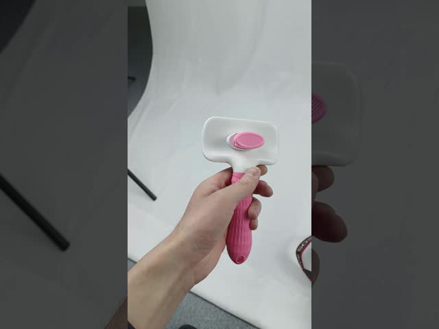 毛の取り外しを切るペット櫛のブラシの鋼鉄ボタンを取除く貝をマッサージする